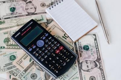 calculator notebook and dollar bills